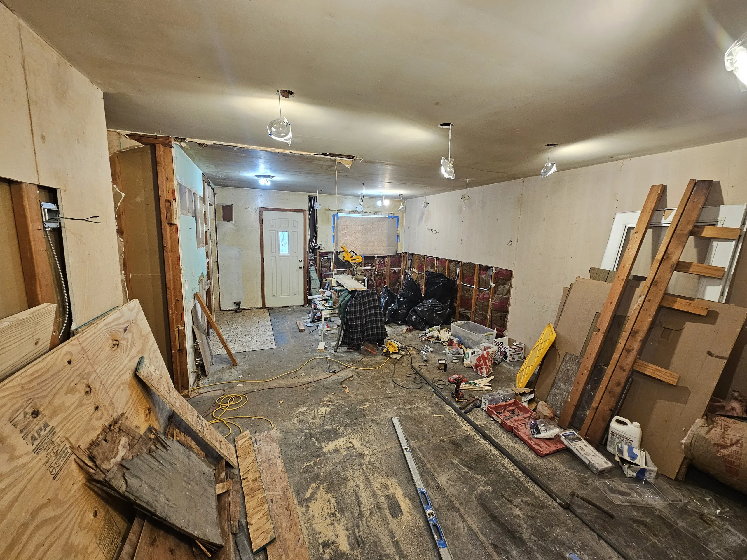 Interior of a renovation project showing a construction area with exposed walls and tools