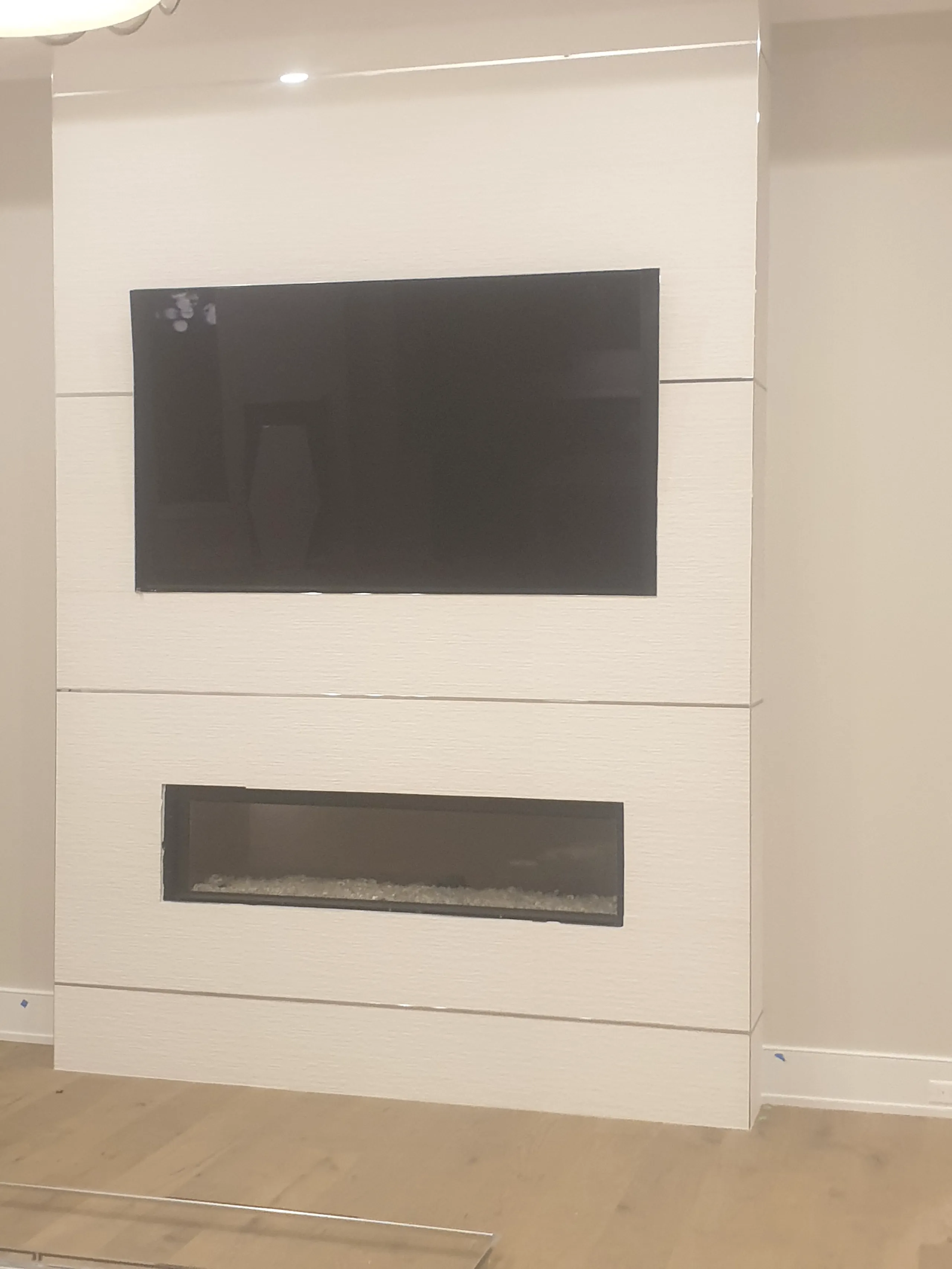 Modern living room design featuring a wall-mounted TV and a contemporary fireplace