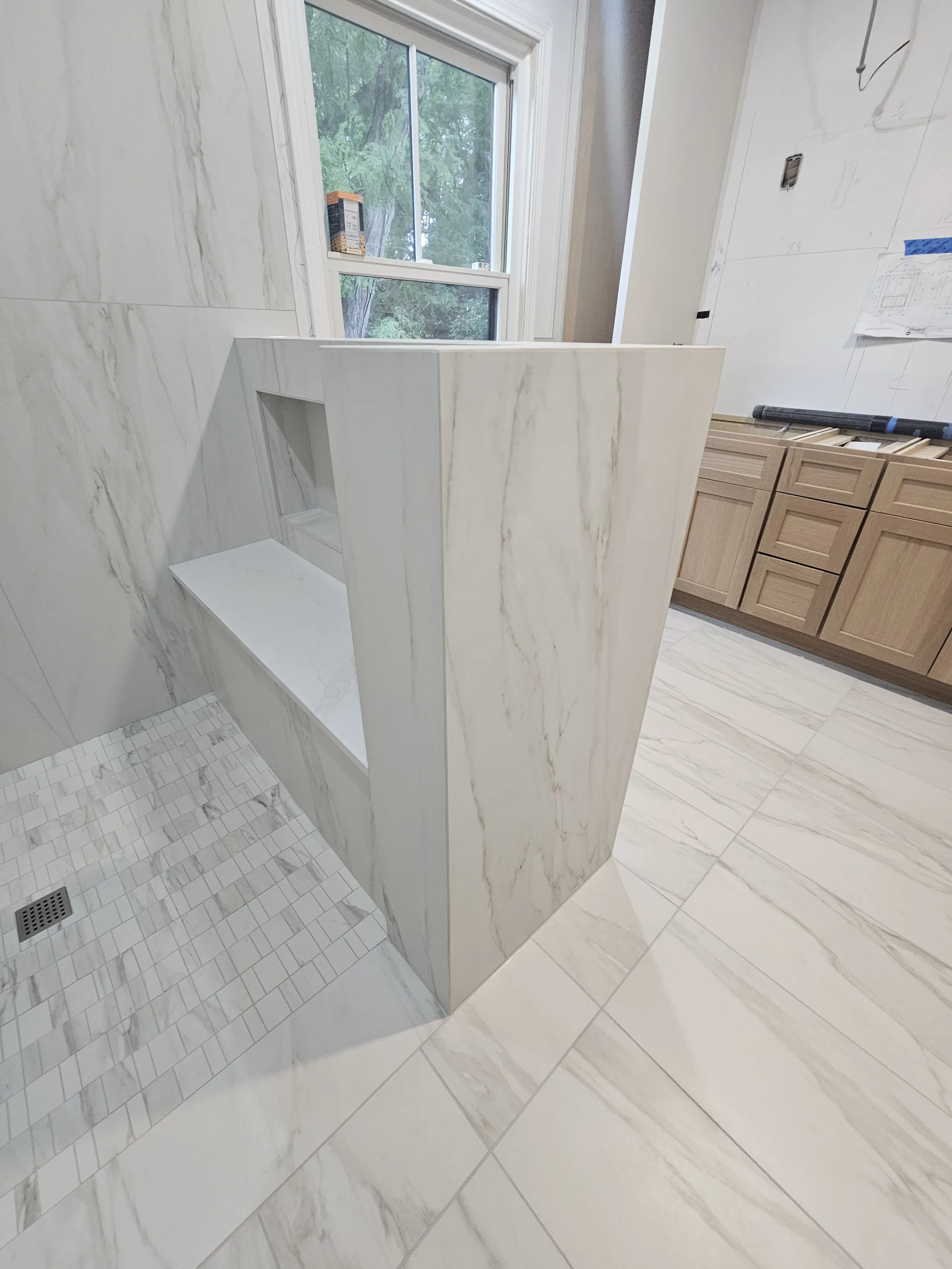 Modern shower remodel showcasing marble tiles and sleek design